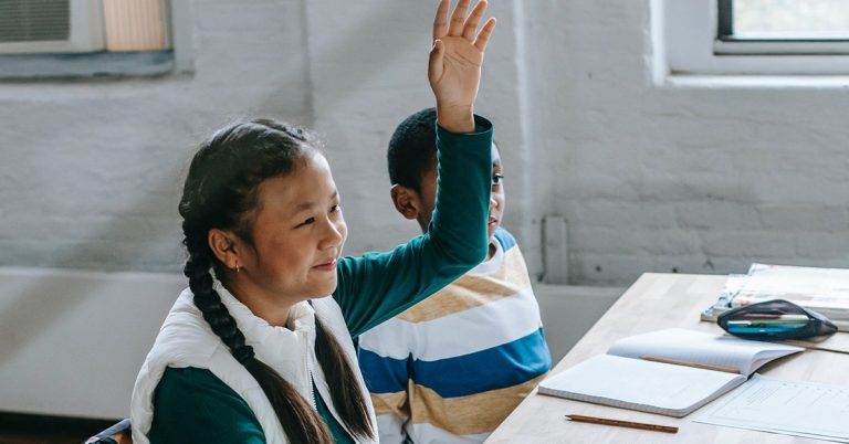 Female student raising hand in classroom
