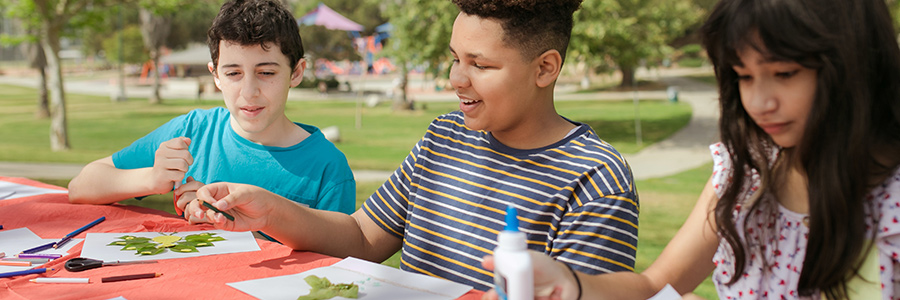 Three students doing educational activities outdoor