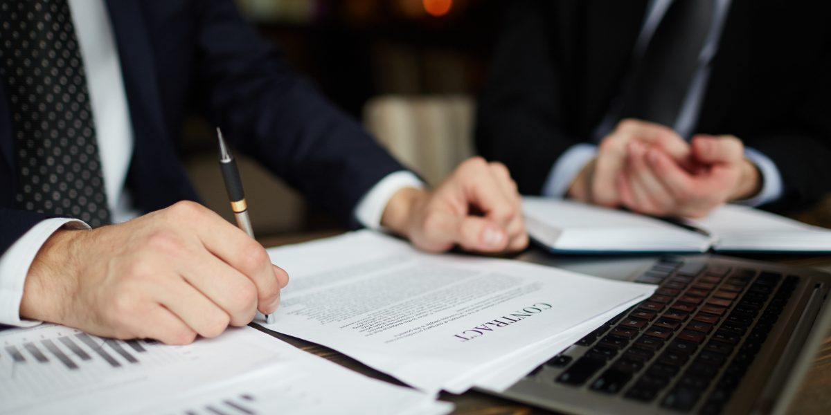 Lawyers-reading-contract Lawyers sitting at the desk and reading contracts