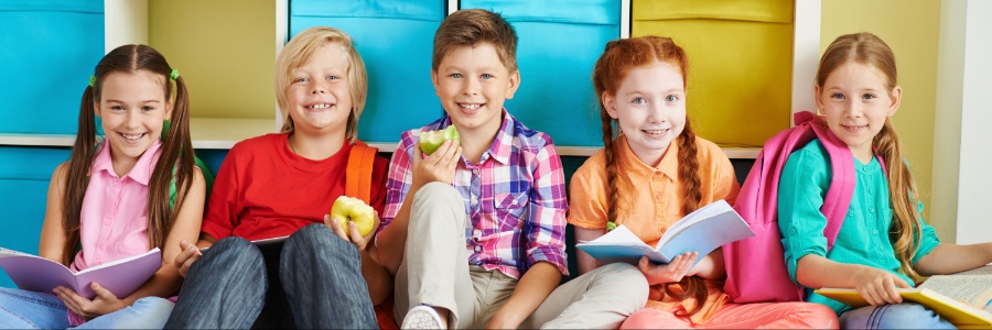 A group of school kids sitting and smiling