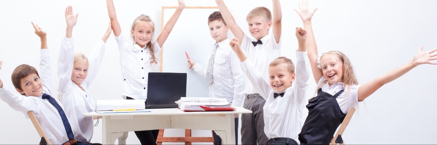Kids in classroom raising hands