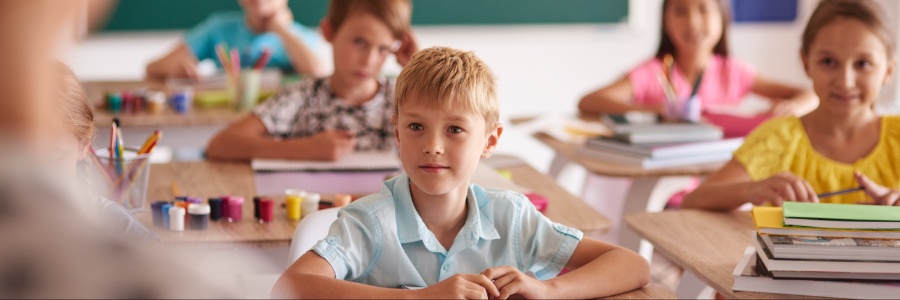 Kids in classroom listening to a teacher